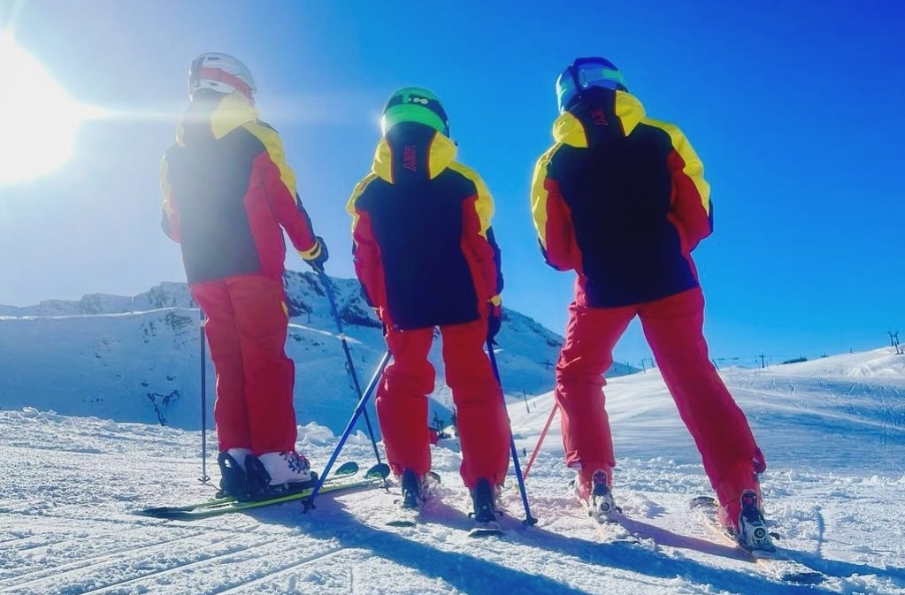 Niños aprendiendo técnica de esquí alpino en diferentes etapas de formación